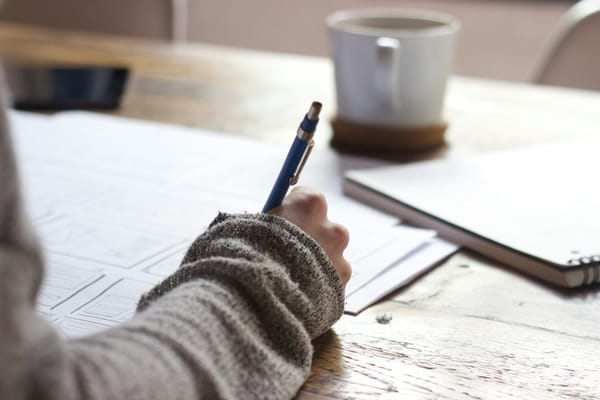 stock image of a student writing on a piece of paper
